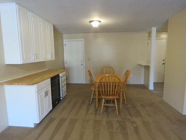 carpeted dining area featuring wine cooler