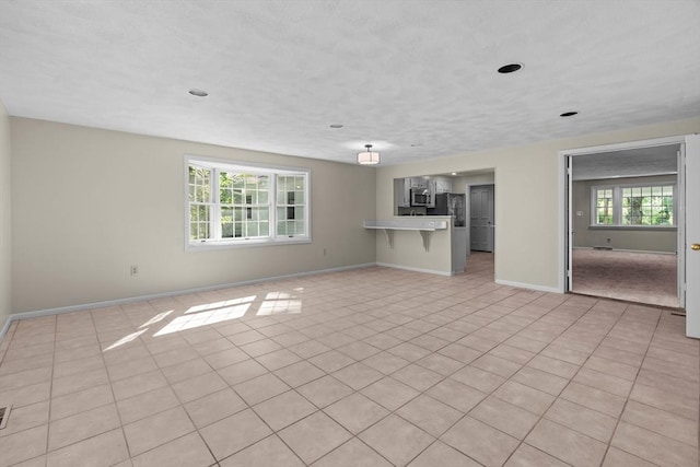 unfurnished living room with baseboards and light tile patterned flooring
