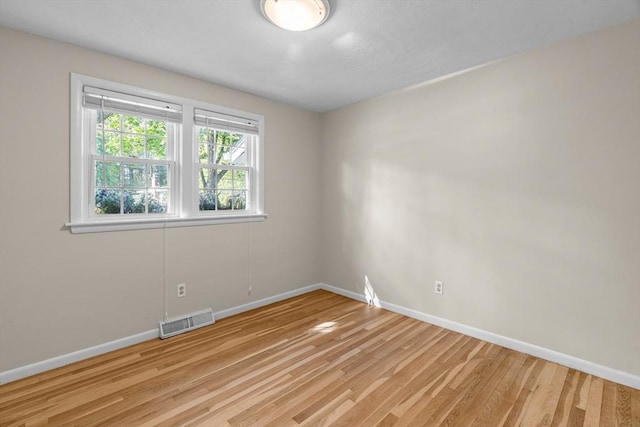 empty room with baseboards and light wood-style floors