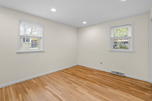 empty room featuring baseboards, light wood finished floors, and recessed lighting