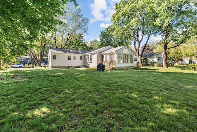 back of property with a lawn and entry steps