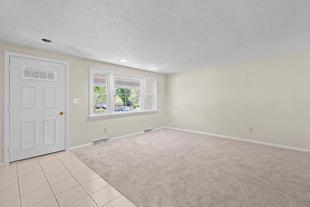entrance foyer featuring light colored carpet, baseboards, light tile patterned floors, a textured ceiling, and recessed lighting