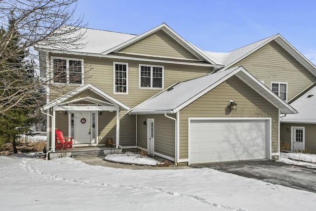 traditional-style house featuring a garage and aphalt driveway