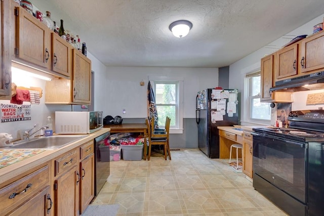 25-29 Chapel St, Norwood, MA 02062 - kitchen with black appliances, under cabinet range hood, a textured ceiling, light countertops, and brown cabinets