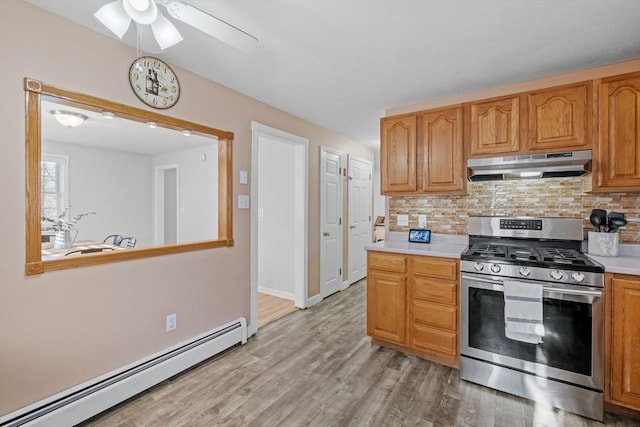 kitchen with baseboard heating, backsplash, light hardwood / wood-style flooring, and stainless steel gas range oven