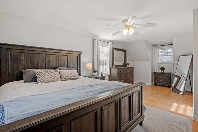 bedroom with lofted ceiling, ceiling fan, and light wood-type flooring