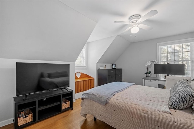 bedroom with multiple windows, vaulted ceiling, ceiling fan, and light wood-type flooring