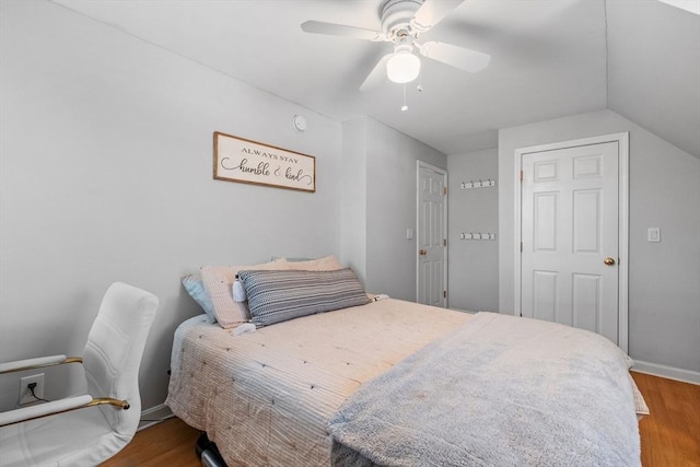 bedroom with hardwood / wood-style flooring, vaulted ceiling, and ceiling fan