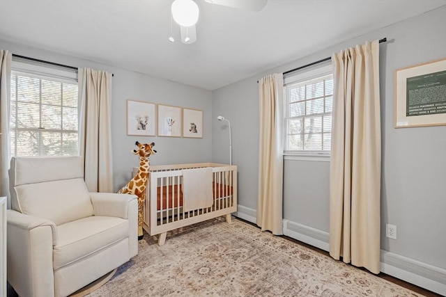 bedroom featuring ceiling fan and a crib