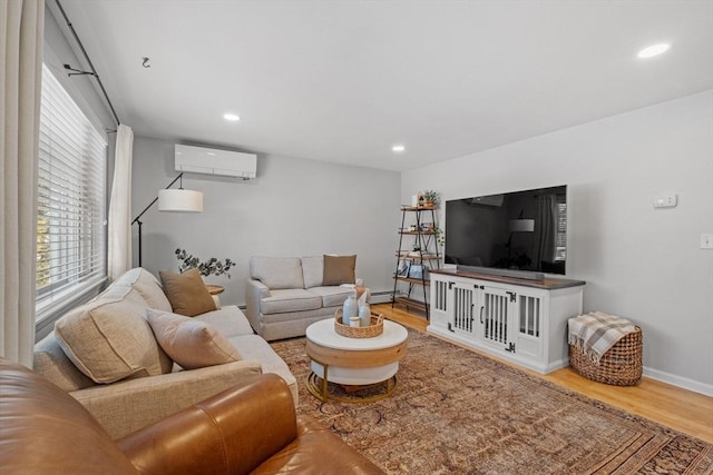 living room with wood-type flooring, a baseboard heating unit, and an AC wall unit