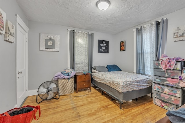 bedroom featuring hardwood / wood-style flooring and a textured ceiling