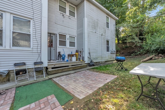 back of property featuring a deck, a lawn, and a patio area