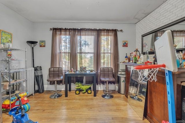 interior space featuring brick wall and hardwood / wood-style flooring