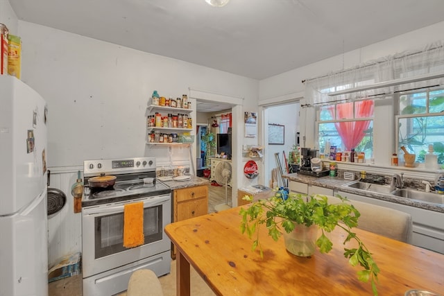 kitchen featuring stainless steel electric range, white refrigerator, and sink