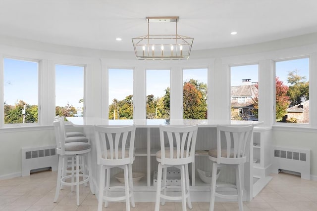 sunroom / solarium with radiator and a notable chandelier