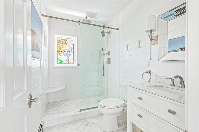 bathroom with toilet, marble finish floor, a stall shower, and vanity