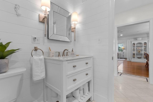 half bath with toilet, baseboard heating, tile patterned flooring, and vanity