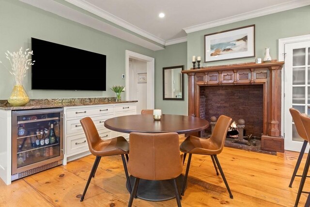 dining space featuring wine cooler, recessed lighting, light wood-style floors, and ornamental molding