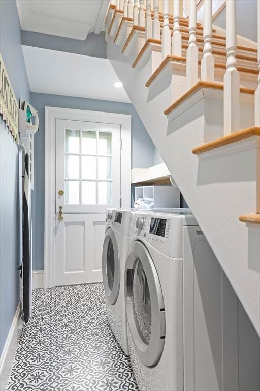 clothes washing area with laundry area, washing machine and dryer, and baseboards