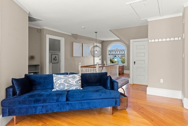 living room featuring visible vents, baseboards, wood finished floors, and crown molding