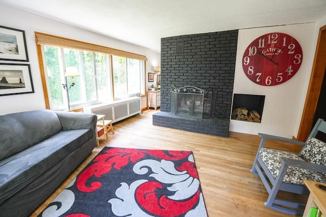 39 Crest Ave, Lunenburg, MA 01462 - living area with radiator, wood finished floors, and a brick fireplace