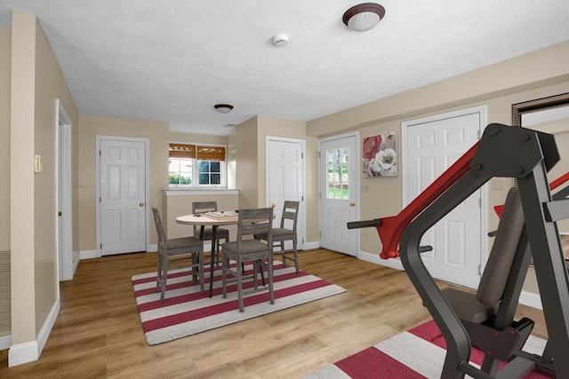 dining space with baseboards and wood finished floors