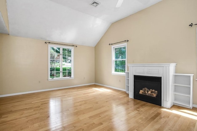 unfurnished living room with light wood-style floors, a healthy amount of sunlight, and visible vents