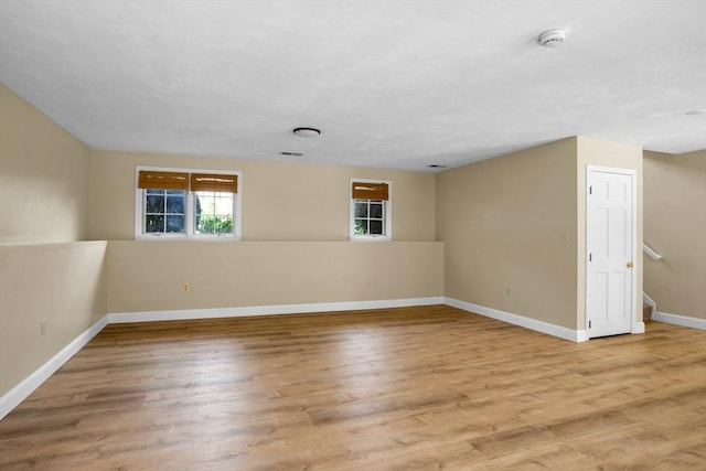 empty room with baseboards, wood finished floors, and visible vents