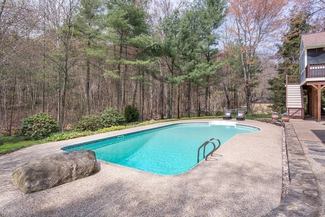 outdoor pool with stairs and a patio