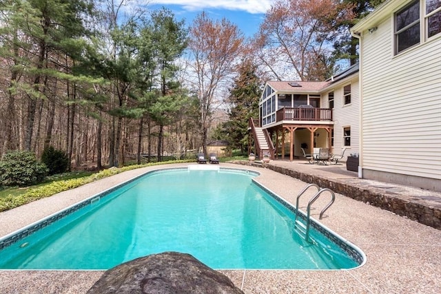 pool with stairs, a patio area, and a deck