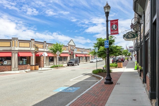 view of street featuring sidewalks, street lighting, and curbs