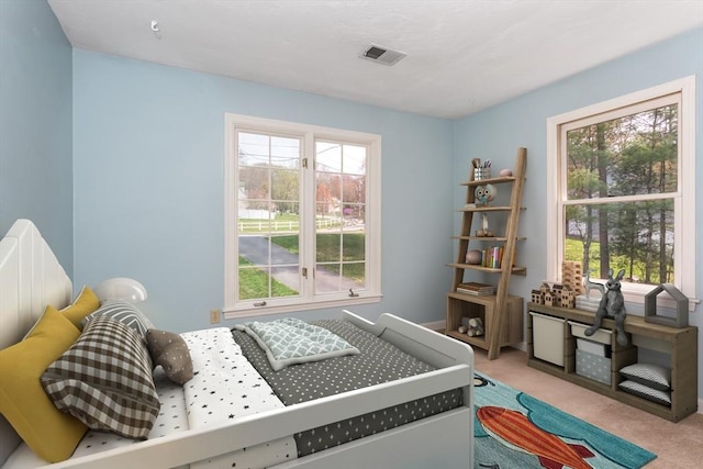 carpeted bedroom featuring visible vents
