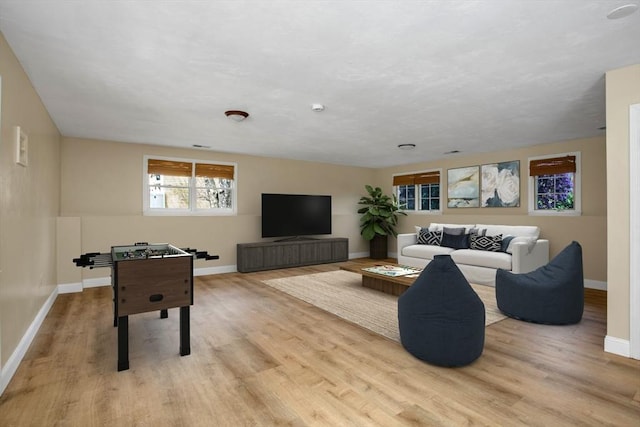 living room featuring baseboards and light wood-style flooring