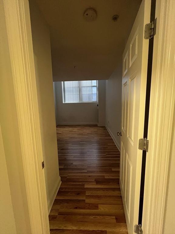 hallway with wood finished floors and baseboards