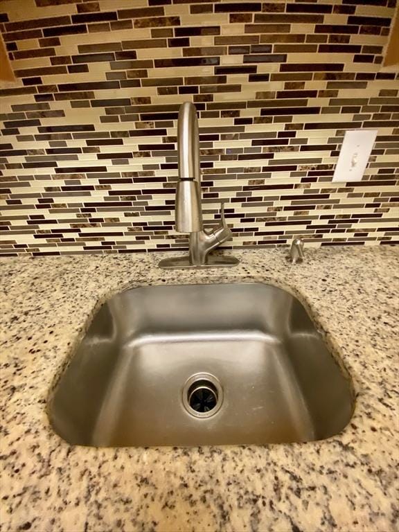 interior details featuring a sink and light stone countertops