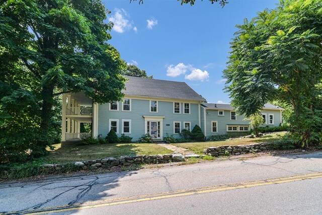 colonial inspired home featuring a front yard