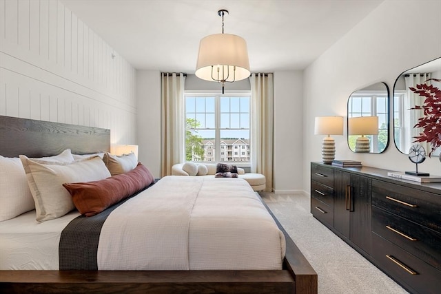 bedroom with light colored carpet and baseboards