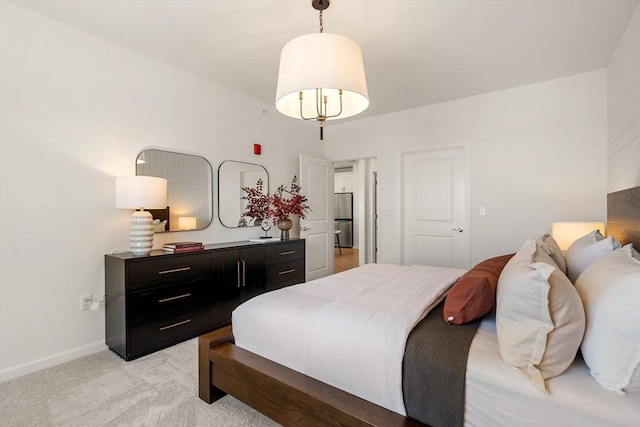 bedroom featuring freestanding refrigerator, baseboards, and light colored carpet