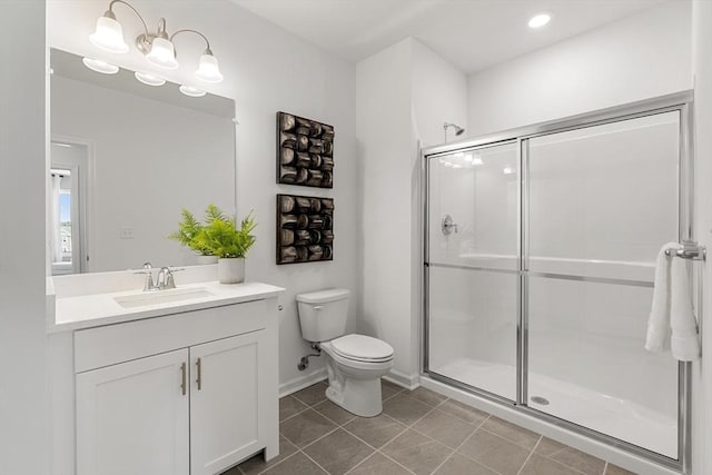 bathroom featuring vanity, toilet, baseboards, tile patterned floors, and a shower stall