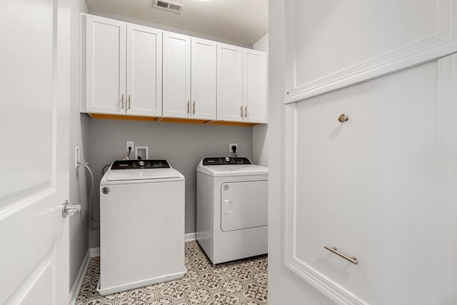 clothes washing area featuring baseboards, washing machine and dryer, cabinet space, and visible vents