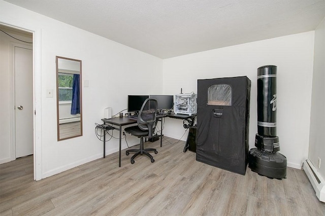 office featuring a baseboard heating unit, baseboards, and wood finished floors