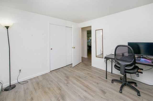 office space featuring baseboards, baseboard heating, and wood finished floors
