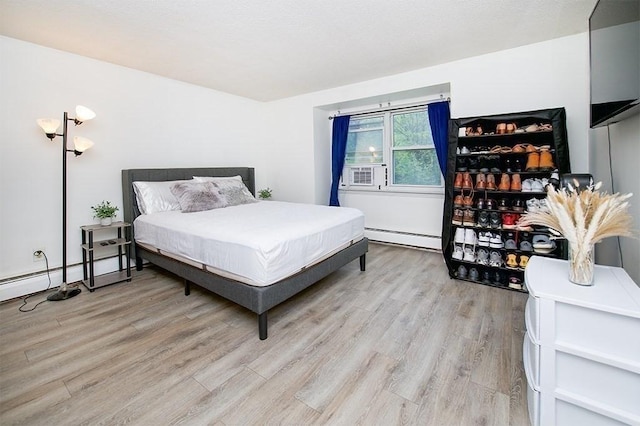 bedroom with light wood-style flooring and a baseboard radiator