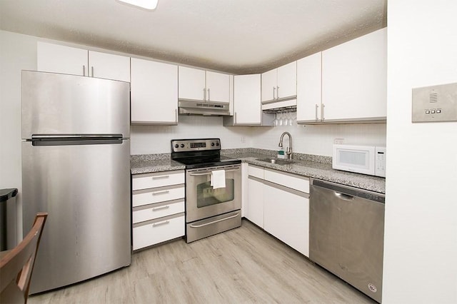 kitchen featuring under cabinet range hood, a sink, light wood-style floors, stainless steel appliances, and white cabinets