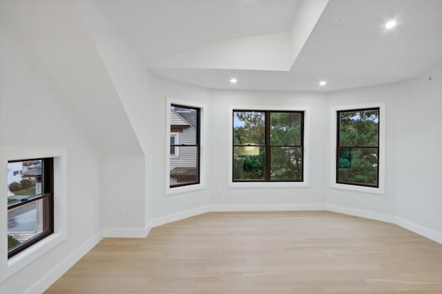 unfurnished room featuring light wood-type flooring and lofted ceiling