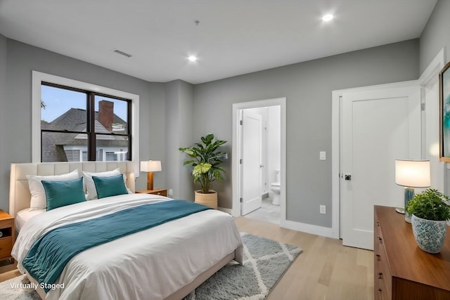 bedroom featuring light hardwood / wood-style floors and ensuite bathroom