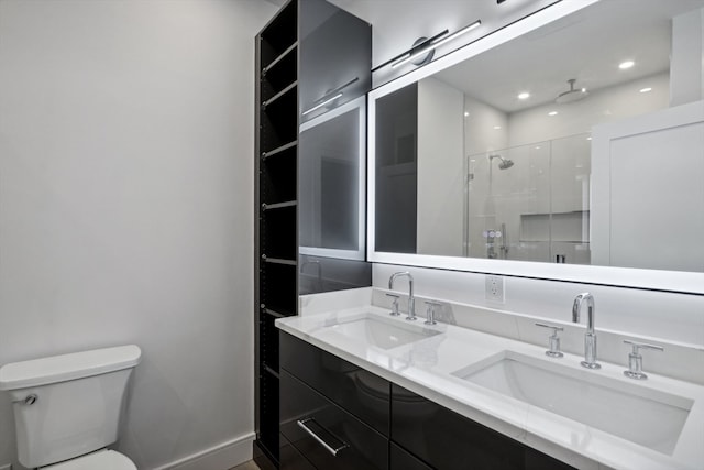 bathroom with a shower with shower door, vanity, and toilet