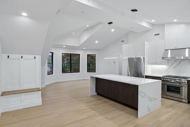 kitchen featuring light stone counters, high end appliances, white cabinetry, a center island, and light wood-type flooring