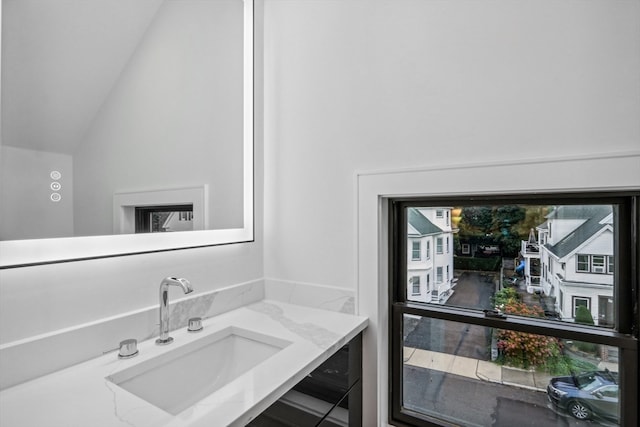 bathroom featuring lofted ceiling and vanity