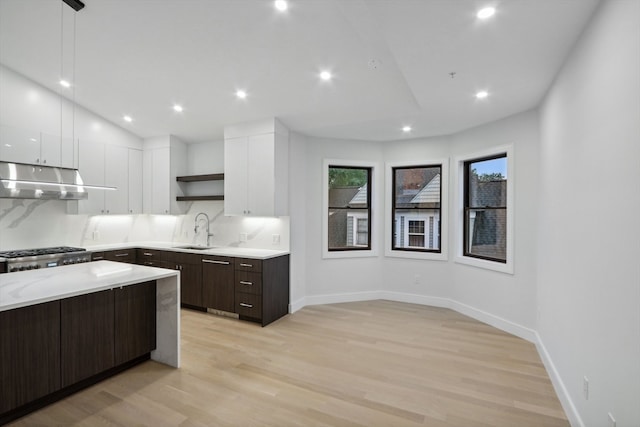 kitchen featuring sink, dark brown cabinets, white cabinetry, stainless steel range, and light hardwood / wood-style floors